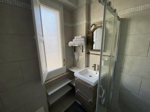 een badkamer met een douche, een wastafel en een raam bij Dimora Bro in Conversano