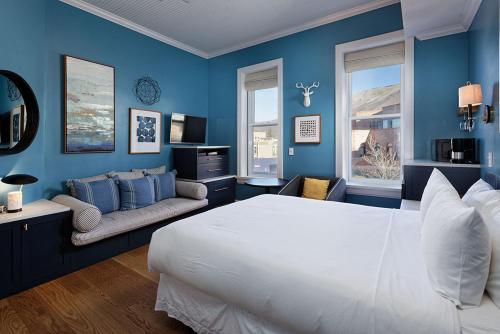 een blauwe slaapkamer met een groot bed en een bank bij Independence Square 205, Stylish Hotel Room with AC, Great Location in Aspen in Aspen