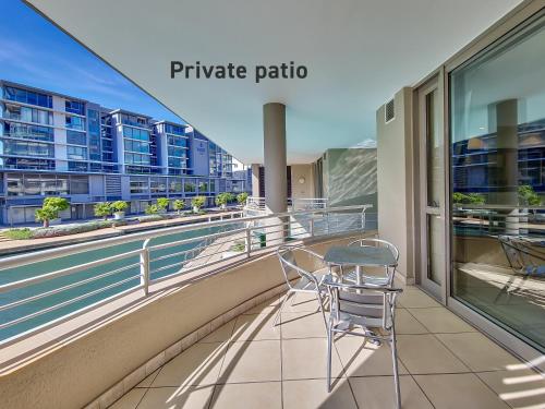 Un balcón con dos sillas y una mesa. en Soak up canal views, Walk to V&A Waterfront and CTICC, en Ciudad del Cabo