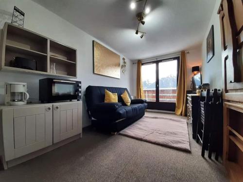 拉費里耶爾的住宿－Appartement vue panoramique au pied des pistes，客厅配有蓝色的沙发和电视