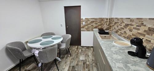 a kitchen with a table and chairs and a sink at Apartament Like Home in Carei