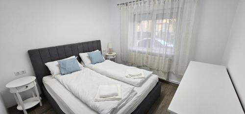 a bedroom with a bed with two pillows and a window at Apartament Like Home in Carei