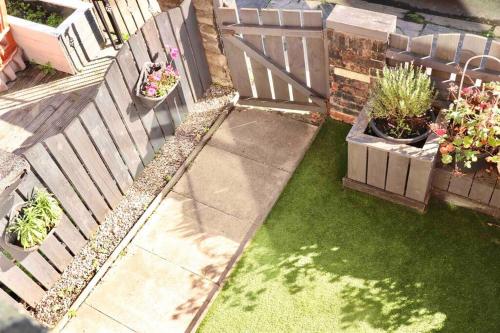 a backyard with a wooden fence and some plants at Stunning Guest House FREE WiFi &Parking in Hunslet