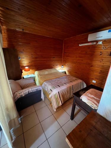 um quarto com duas camas e um sofá em Cabañas La Delfina em Puerto Iguazú