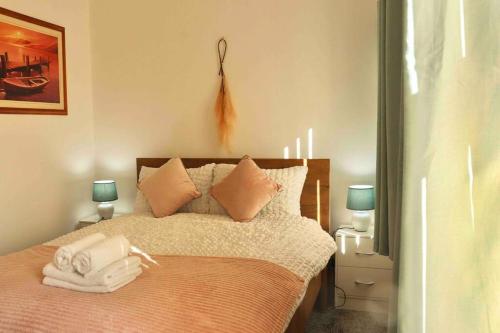 1 dormitorio con 1 cama con toallas en Stunning Guest House FREE WiFi &Parking, en Hunslet
