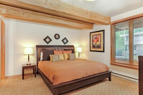 een slaapkamer met een groot bed en 2 lampen bij Chateau Roaring Fork Unit 22, Spacious Condo with Beautiful River Views, 4 Blocks to Town in Aspen