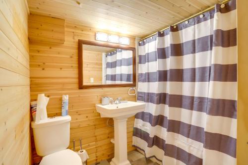 a bathroom with a toilet and a sink in a log cabin at Peaceful South Bend Vacation Rental with Fire Pit in South Bend