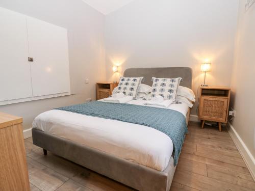 a bedroom with a large bed and two night stands at Hall Garth Cottage in Leyburn