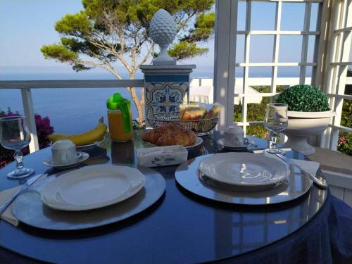 a blue table with plates of food on a balcony at la guardia in Anacapri
