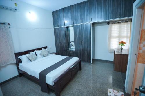a bedroom with a large bed in a room at Velvet Vista Premier Service Apartments in Mysore in Mysore