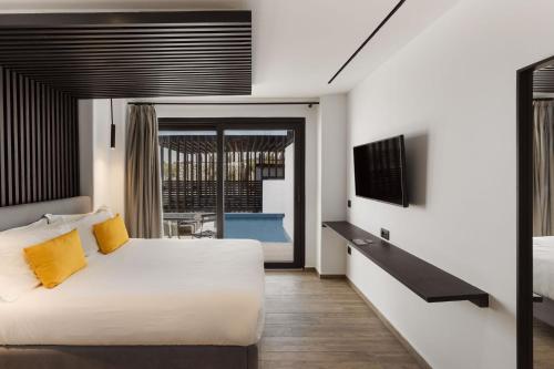 a bedroom with a large bed and a tv at Mazera Boutique Hotel in Mýkonos City