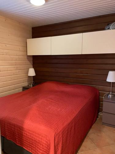 a bedroom with a bed with a red blanket at Aapeli 1 in Ähtäri