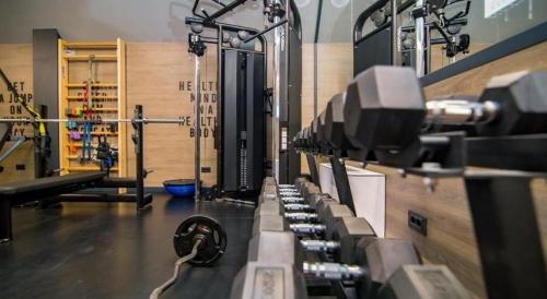 a gym with a row of monitors on a wall at Apartman Lux Titova Vila Plus Sony PS in Zlatibor