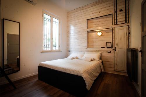 a bedroom with a bed with a wooden wall at Fermata 135 B&B in Grottammare