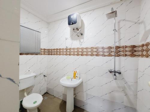 uma casa de banho branca com um WC e um lavatório em Dezra Homes em Lagos