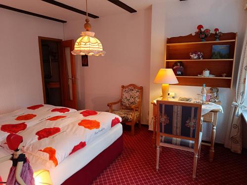 a bedroom with a bed and a table and a lamp at Wellness und Romantik Hotel Helmboldt in Bad Sachsa