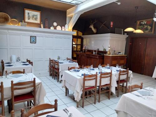 Au cœur bion في بوالون: غرفة طعام مع طاولات بيضاء وكراسي في مطعم