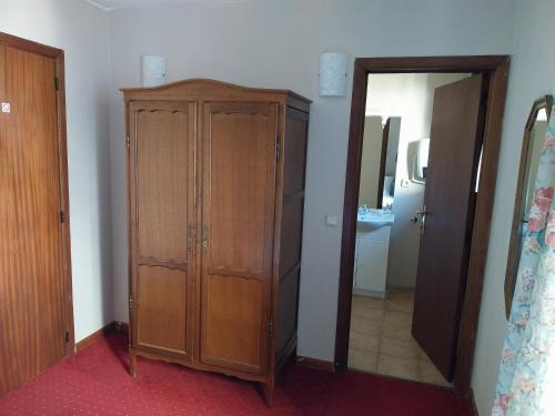 a bedroom with a wooden cabinet and a mirror at Au cœur bion in Bouillon