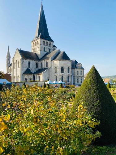 a large building with a tower on top of a field at Maison La folie douce in Saint-Pierre-de-Manneville