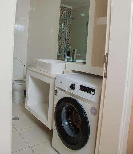 un bagno con lavatrice e lavandino di The Queen a Luanda