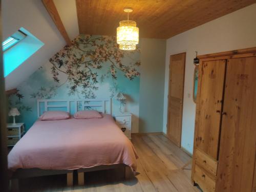 una camera con letto e parete floreale di Au pied de la colline ad Alembon