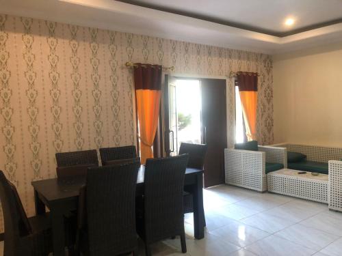 d'une salle à manger avec une table, des chaises et une fenêtre. dans l'établissement Hotel Pantai Mutiara, à Pelabuhan Ratu