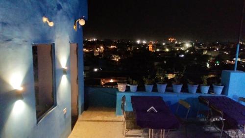 a balcony with a view of a city at night at Sunshine Guest House & Restaurant in Jodhpur