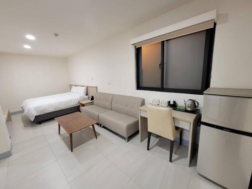 Habitación de hotel con cama y sofá en 悠而行旅, en Nangan