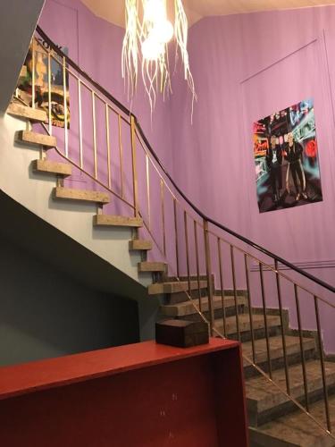 a staircase in a room with a purple wall at Noer Hostel in Larnaka