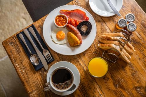 einen Tisch mit einem Frühstücksteller und einer Tasse Kaffee in der Unterkunft The Lansdowne Guest House in Bourton on the Water