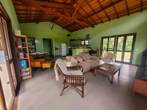 ein Wohnzimmer mit einem Sofa und einem Tisch in der Unterkunft Casa de campo com piscina no Vale das Videiras in Petrópolis