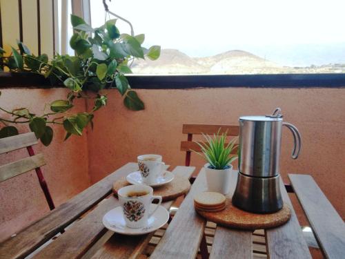 un tavolo di legno con due tazze di caffè sopra di Live Puertito Cortes a Puertito de Güímar