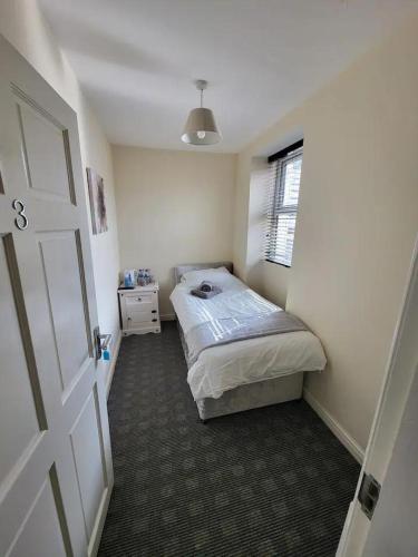 a small bedroom with a bed and a window at The Dulbin Packet - Single room 1 in Holyhead