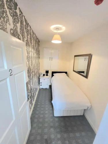 1 dormitorio con cama blanca y puerta blanca en The Dulbin Packet - Single room 1, en Holyhead