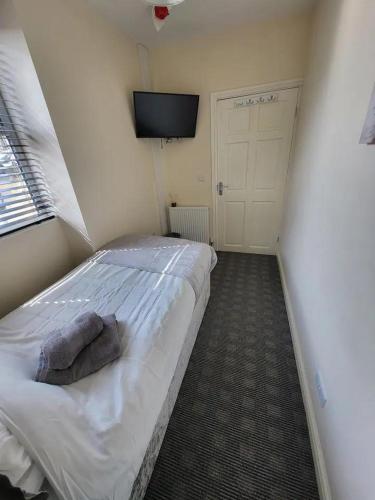 a bedroom with a bed with a television on the wall at The Dulbin Packet - Single room 1 in Holyhead
