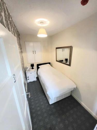um quarto com uma cama branca e um espelho em The Dulbin Packet - Single room 1 em Holyhead