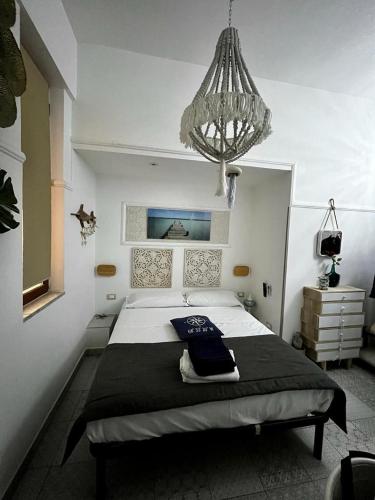 a bedroom with a large bed with a chandelier at Casale D' Or in Palermo