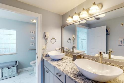 uma casa de banho com 2 lavatórios e um espelho grande em Boardwalk Beach Resort 1900 em Panama City Beach