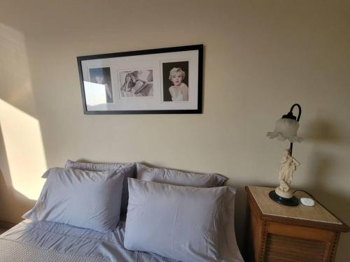 a bedroom with a bed with a picture on the wall at Espaçoso Apartamento no Centro in Rio de Janeiro