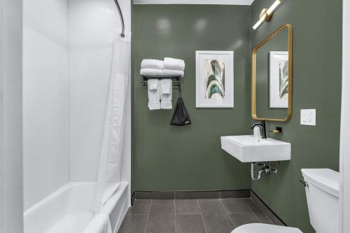 baño con paredes verdes, lavabo y bañera en Nob Hill Hotel en San Francisco