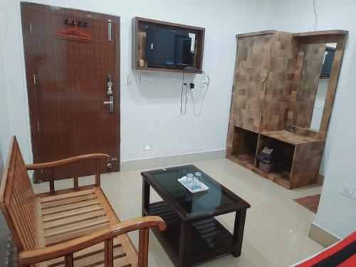 a living room with a table and a chair and a tv at Hotel Knight Inn Airport in Guwahati