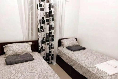 a bedroom with two beds and a window at FOMAG House GenSan 2BR in General Santos