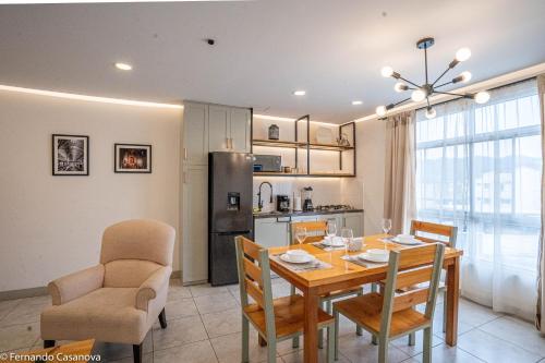 cocina y comedor con mesa y sillas en Praga Apartamentos Guayaquil Urdesa, en Guayaquil