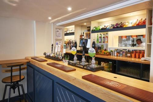 a bar in a restaurant with a counter with alcohol at The Royal in Wallingford