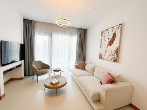 Luxury living at Vida Marina & Yacht Club في دبي: غرفة معيشة مع أريكة وتلفزيون