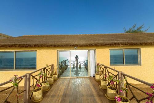 a person is standing on a house with a balcony at Villas Badiene in Poponguine