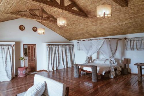 a bedroom with a bed in a room with wooden floors at Villas Badiene in Poponguine