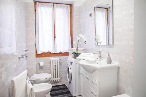 a white bathroom with a toilet and a sink at Delightful shanti home in Milan