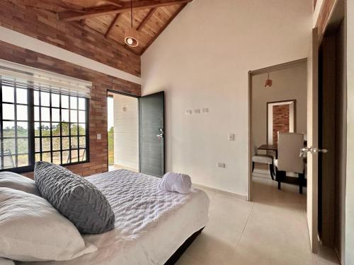 1 dormitorio con 1 cama con pared de ladrillo en Casa Roca con piscina Hospedaje Campestre, en Los Santos