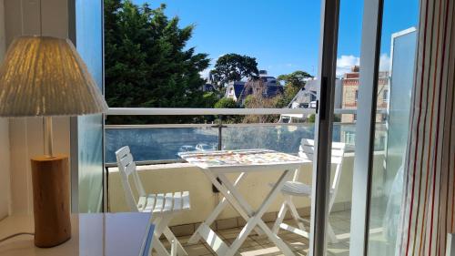 un balcon avec une table, des chaises et une fenêtre dans l'établissement Studio Judith - Dinard Plage, à Dinard